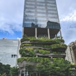 Symbolbild grüne Gebäude dank Gebäudemanagement: Ein Bürohochhaus in Singapur, dessen untere Stockwerke aus üppig begrünten Terrassen besteht.