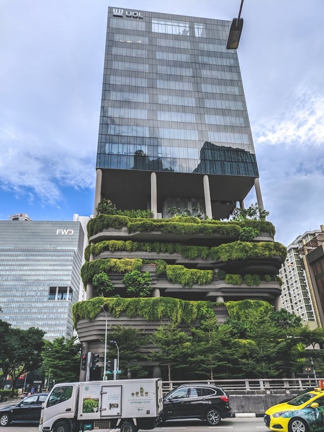 Symbolbild grüne Gebäude dank Gebäudemanagement: Ein Bürohochhaus in Singapur, dessen untere Stockwerke aus üppig begrünten Terrassen besteht.